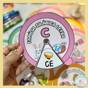 **Roletas das Famílias Silábicas Simples – Alfabetização** O arquivo com 21 Roletas das Famílias Silábicas Simples é um recurso pedagógico desenvolvido para trabalhar leitura de sílabas e formação das famílias silábicas com crianças em fase de alfabetização de forma lúdica, visual e interativa. Cada roleta apresenta as sílabas da família silábica e figuras ilustradas que iniciam com cada sílaba, facilitando a associação entre som, imagem e escrita. A proposta torna o aprendizado mais compreensível, dinâmico e significativo para as crianças. O recurso auxilia no desenvolvimento da leitura, oralidade e consciência fonológica, além de incentivar a participação ativa durante as atividades de alfabetização. Benefícios da proposta: • Trabalha famílias silábicas simples; • Estimula leitura de sílabas e palavras; • Desenvolve consciência fonológica; • Incentiva pronúncia correta das sílabas; • Favorece aprendizagem visual e interativa; • Promove participação ativa das crianças; • Estimula autonomia e autoconfiança; • Possibilita diferentes atividades de alfabetização; • Incentiva criatividade e expressão oral. Recomendação de impressão: • Papel com gramatura 180 ou 230; • Colchetes para unir as partes da roleta. Arquivo em PDF pronto para impressão.